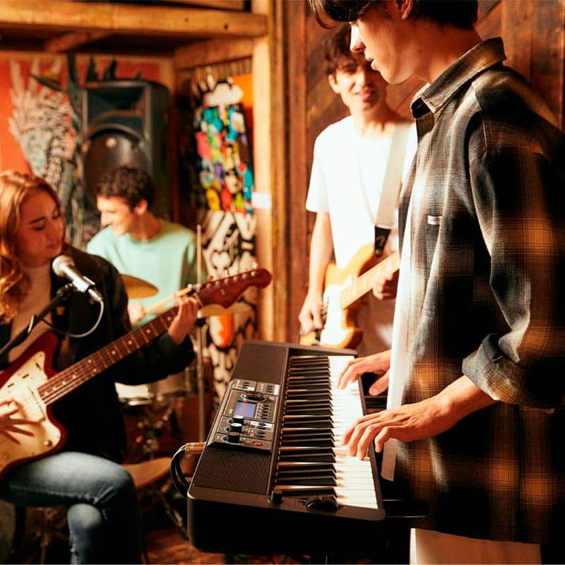 vista de uma banda com integrantes tocando teclado e guitarra
